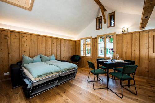 Schlafzimmer mit einem Bett, einem Tisch und Stühlen in der Unterkunft Ferienhaus Chalet Steckli in Brienz