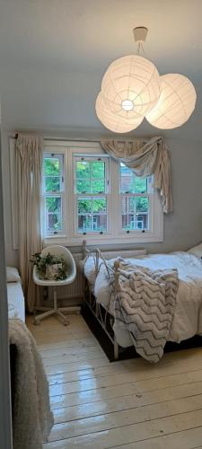 a bedroom with a bed and a table and windows at One Bedroom House in a Quiet Neighbourhood in London