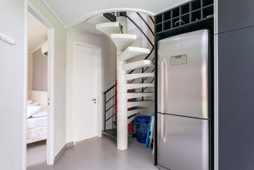 a kitchen with a spiral staircase and a refrigerator at Flat ou Bangalo Luxo Beach Class Beira Mar Muro Alto in Porto De Galinhas
