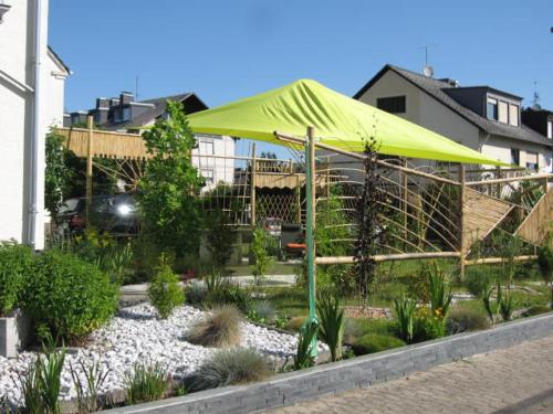 a yellow umbrella in a garden in front of a house at Diamanthaus 3 Koblenz in Koblenz
