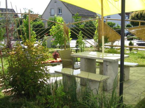 a picnic table with a chair and an umbrella at Diamanthaus 3 Koblenz in Koblenz