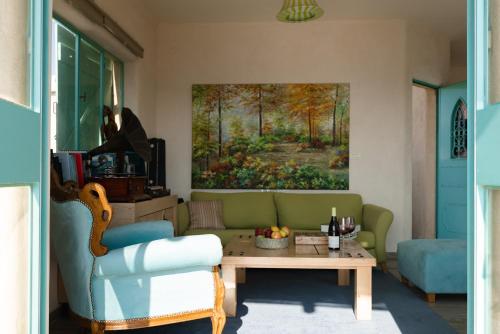 a living room with a green couch and a table at בית אירוח אישי/זוגי ומשפחתי בגליל התחתון אבטליון in Avtalyon