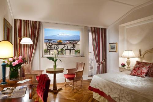 a bedroom with a bed and a table and a window at Grand Hotel Timeo, A Belmond Hotel, Taormina in Taormina