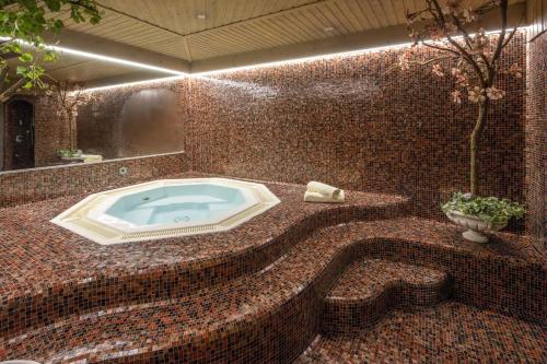 a bathroom with a jacuzzi tub in a mosaic wall at Garni Zimmerhofer in Campo Tures
