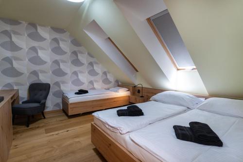 um quarto com 2 camas individuais e uma cadeira em TATRYSTAY Luxury Penthouse Apartment PodLesom em Dolný Smokovec