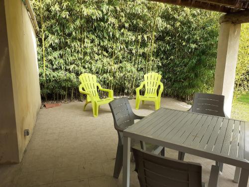 quatre chaises jaunes et une table et une table et des chaises dans l'établissement Petit Mazet Fruits rouges, à Eyragues