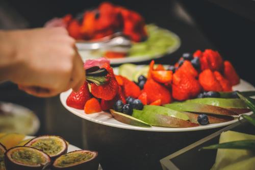 a person is reaching for a plate of fruit at Hotel Astoria in Ravenna