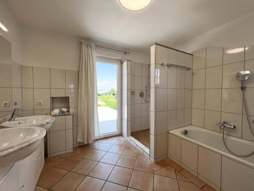 a bathroom with two sinks and a tub and a shower at Apartment Sunshine in Höchst