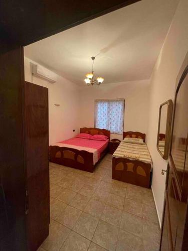 a bedroom with two beds and a couch at Apartament in Shëngjin