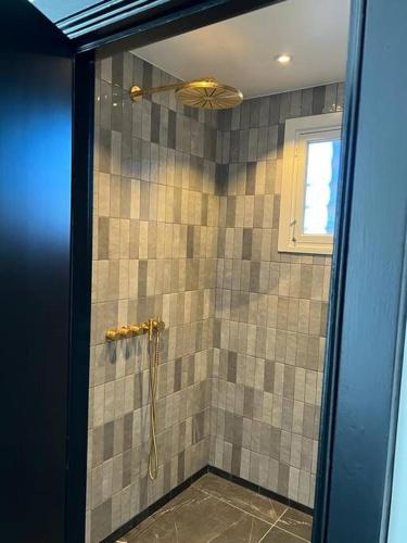 a bathroom with a shower with a glass door at Designer apartment in Charlottenlund