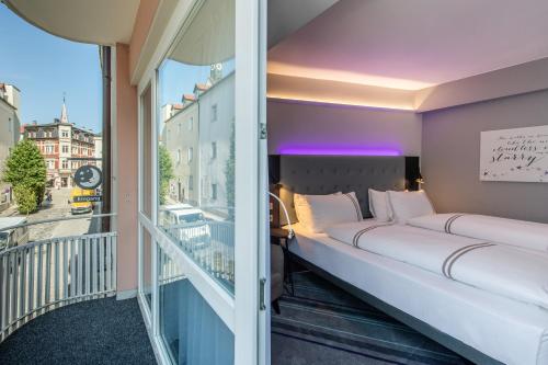 a room with two beds on a balcony at Premier Inn Passau Weisser Hase in Passau