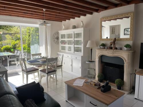 a living room with a couch and a fireplace at Le Courtil in Cerisy-la-Forêt