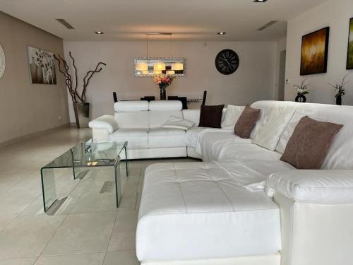 uma sala de estar com sofás brancos e uma mesa de vidro em Luxury 3-Bedroom Apartment in St Julians em St. Julian's