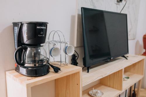 uma cafeteira numa bancada ao lado de uma televisão em Pousada Bom Sucesso 59 em Olinda