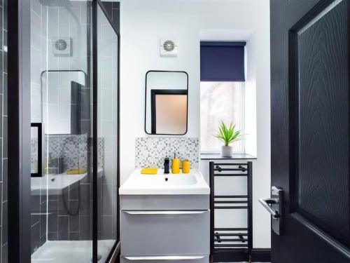 a bathroom with a sink and a shower and a mirror at Luxurious 3 bedroom Flat in Liverpool