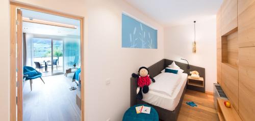a bedroom with a bed with a doll sitting on it at Parc Hotel Am See in Caldaro