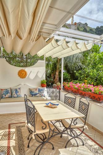 a table and chairs under an umbrella on a patio at Le Botteghe 59 Capri in Capri