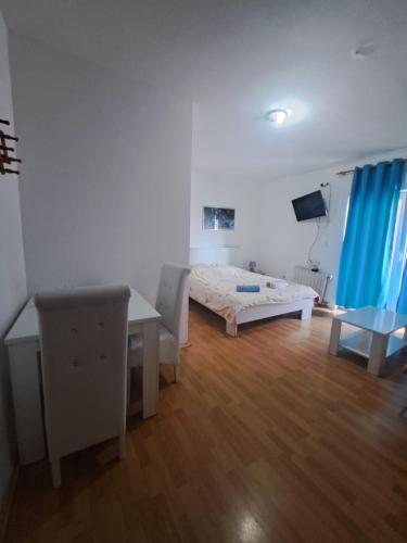 a bedroom with a bed and a desk and a table at Hoste Pikante in Pančevo