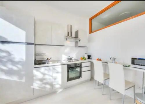 a white kitchen with white cabinets and a sink at Apartment With View Lake Maggiore/Laveno Mombello in Laveno