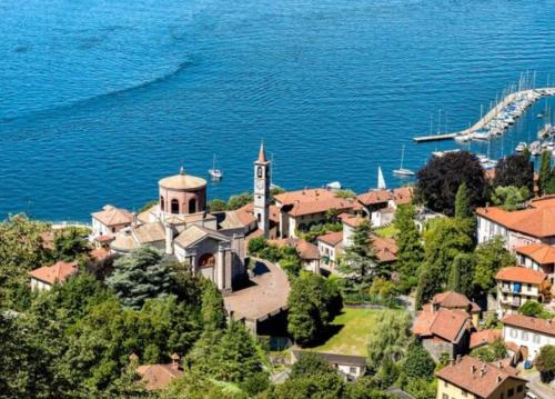 a town with a clock tower on a hill next to the water at Apartment With View Lake Maggiore/Laveno Mombello in Laveno