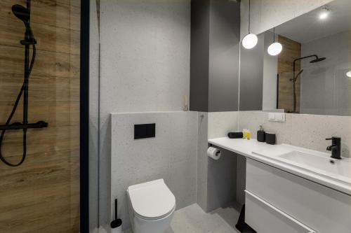 ein Badezimmer mit einem WC, einem Waschbecken und einem Spiegel in der Unterkunft Apartament Radosny in Kudowa-Zdrój