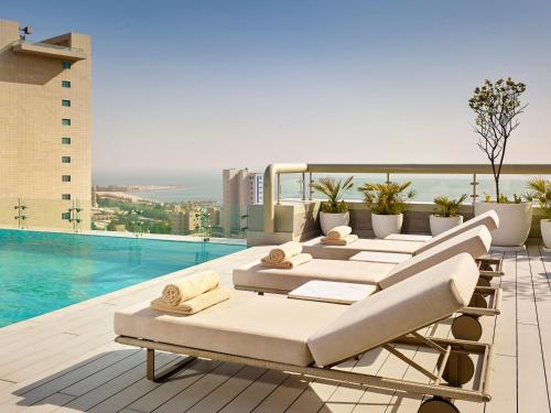 a row of chaise lounges on the rooftop of a hotel at Hyatt Regency Al Kout Mall in Kuwait