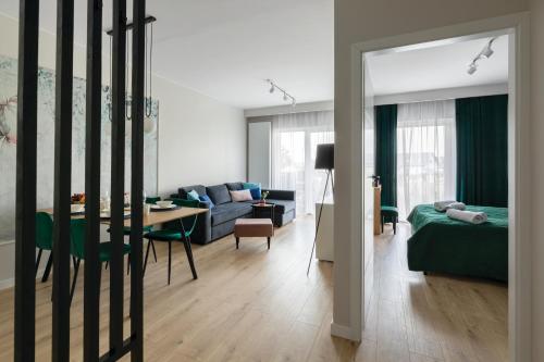 ein Wohnzimmer mit einem Sofa und einem Tisch in der Unterkunft Apartament Radosny in Kudowa-Zdrój