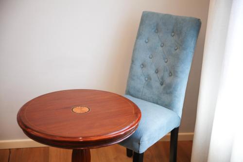 a wooden table and a blue chair with a wooden table and a wooden table at Hotel Foresteria Baglio Della Luna in San Leone