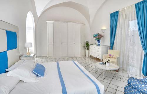 a large bedroom with a large bed and blue curtains at Le Botteghe 59 Capri in Capri