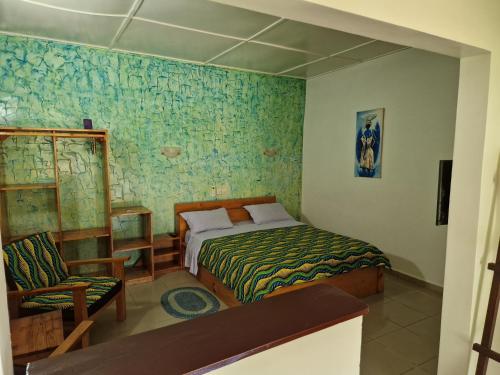 1 dormitorio con 1 cama y 1 silla en Hotel Robinson Plage en Lomé