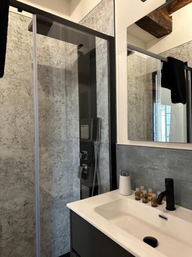 a bathroom with a sink and a shower at La dimora della Giudecca - 13 in Cuneo