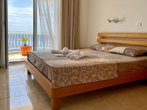 a bedroom with a bed with a view of the ocean at Apartments & Rooms Elite in Dobra Voda