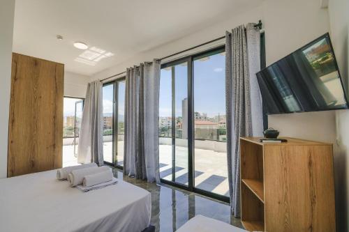 a bedroom with a bed and a large window at Vullkan Hotel in Ksamil