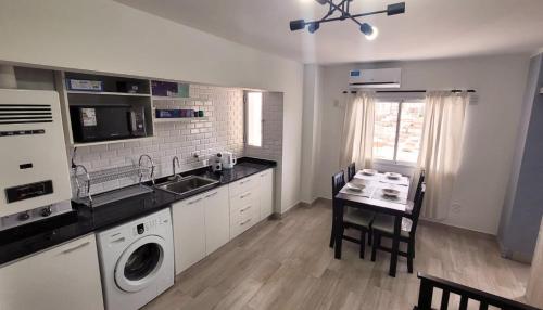 cocina con fregadero y mesa con lavadora en Nice Full Apartment Downtown Salta en Salta