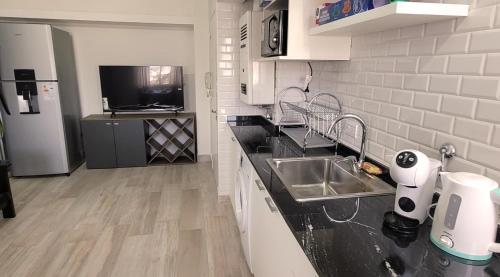 cocina con fregadero y encimera en Nice Full Apartment Downtown Salta en Salta