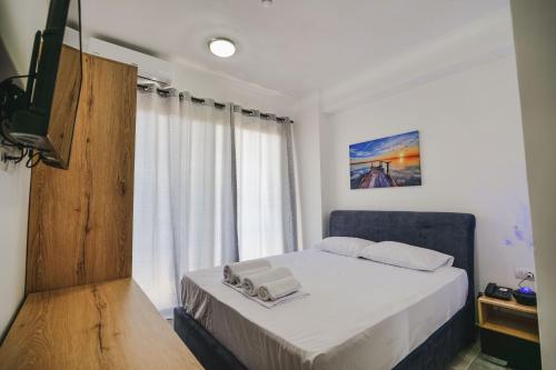 niewielka sypialnia z łóżkiem i oknem w obiekcie Vullkan Hotel w mieście Ksamil