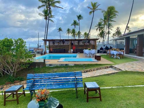 a house with a blue bench and a swimming pool at Pousada a Capela in Arembepe