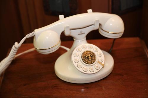 a white phone sitting on top of a table at Hotel Foresteria Baglio Della Luna in San Leone