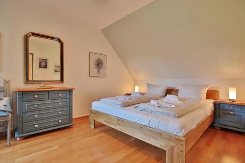 - une chambre avec un lit, une commode et un miroir dans l'établissement Am Rosenhain 19 Am Rosenhain 19 Appartement 3, à Timmendorfer Strand