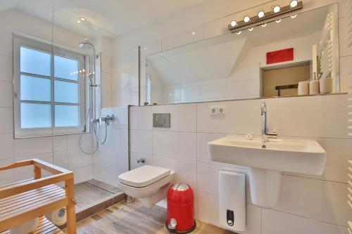 La salle de bains blanche est pourvue d'un lavabo et de toilettes. dans l'établissement Am Rosenhain 19 Am Rosenhain 19 Appartement 3, à Timmendorfer Strand