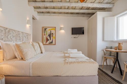um quarto branco com uma cama grande e uma televisão em Villa da Comporta - Quarto Praia da Arrábida T0 em Comporta