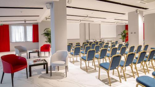 a room with rows of chairs and tables in a room at Hotel American Palace Eur in Rome