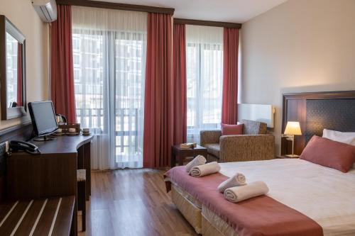 ヴェリングラードにあるАпартамент и Студия "Спа Вълшебство"のベッドとリビングルームが備わるホテルルームです。