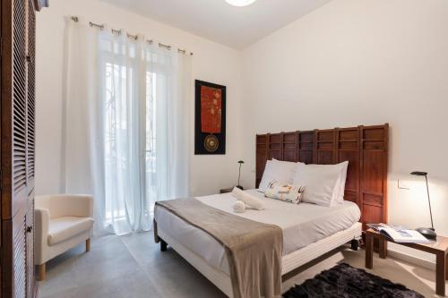 une chambre avec un grand lit et une chaise dans l'établissement HOME ART, à Nice