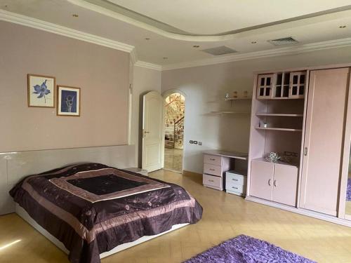 a bedroom with a large bed and a closet at Super luxurious villa with large landscape areas in Cairo