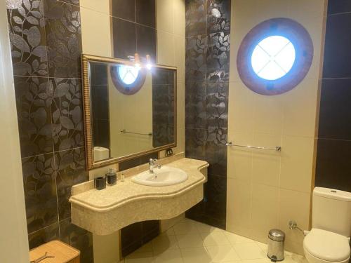 a bathroom with a sink and a mirror and a toilet at Super luxurious villa with large landscape areas in Cairo