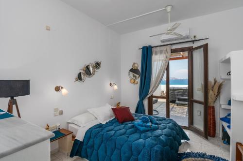 a bedroom with a bed and a view of the ocean at Iliovasilema Studios in Mytakas