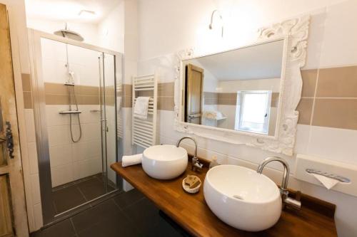 a bathroom with two sinks and a shower at Hotel La Bastide d'Eygalières in Eygalières