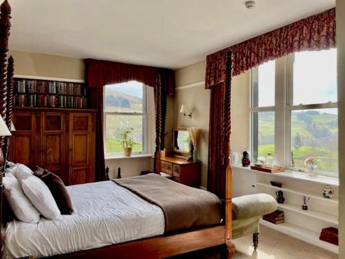 um quarto com uma cama e duas janelas em The Mortal Man Inn em Troutbeck