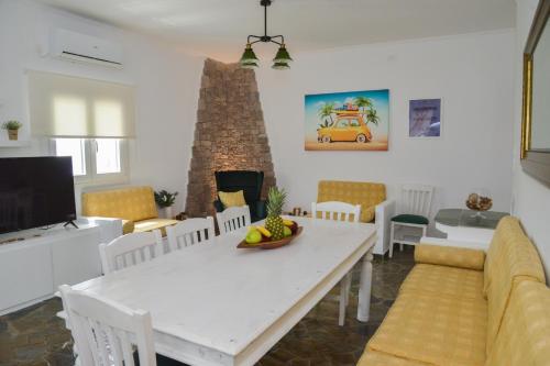 a dining room with a white table and a fireplace at Traditional Villa Relax in Zefiría